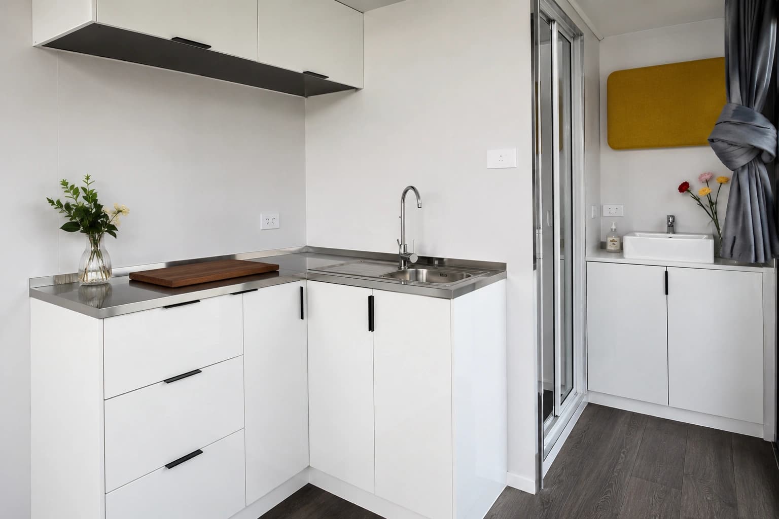 The compact kitchenette with sink, stone benchtop and integrated cabinetry